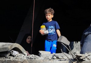 Palestinski dečak na ivici srušene zgrade u Gazi | Foto: REUTERS/Dawoud Abu Alkas