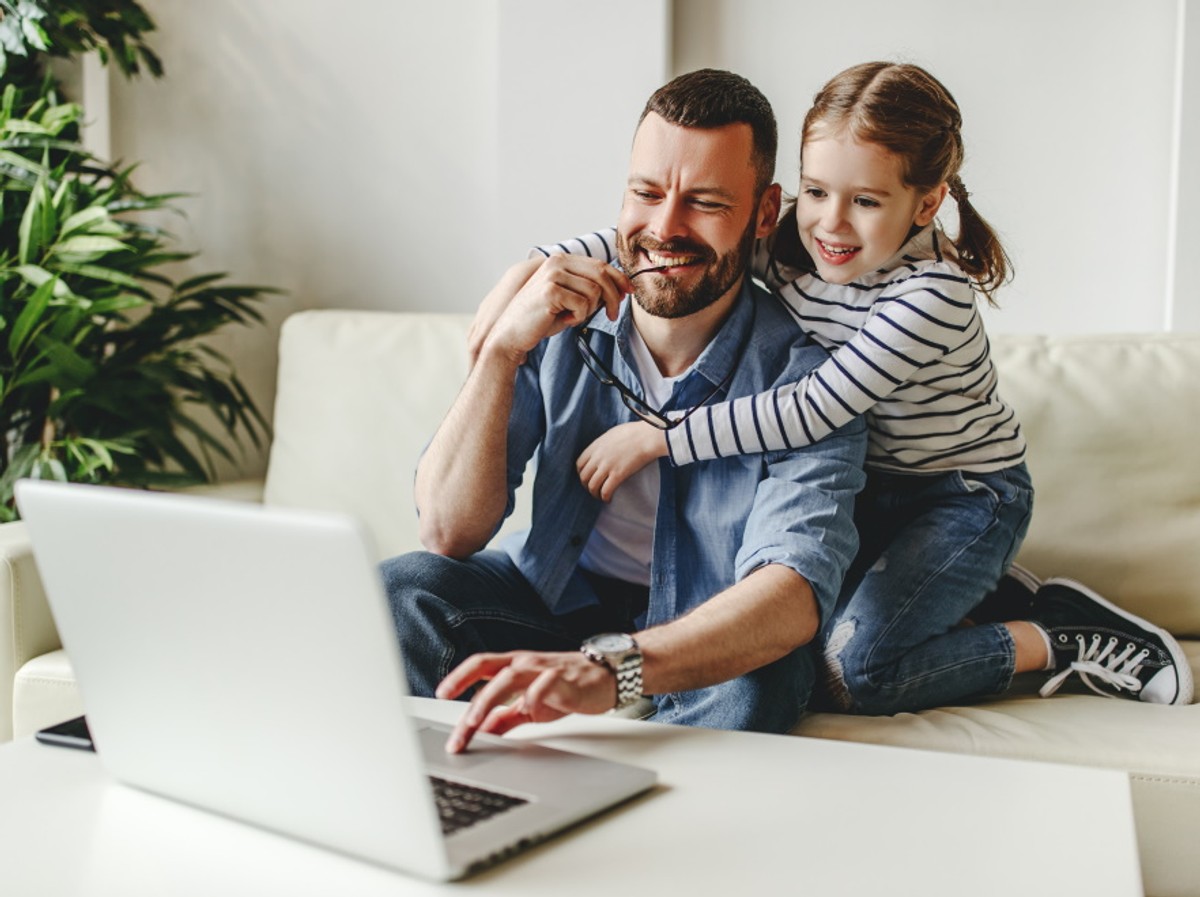 Ojciec z córką pracuje przy komputerze. Home office