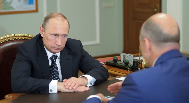 Russian President Vladimir Putin speaks with Finance Minister Anton Siluanov.