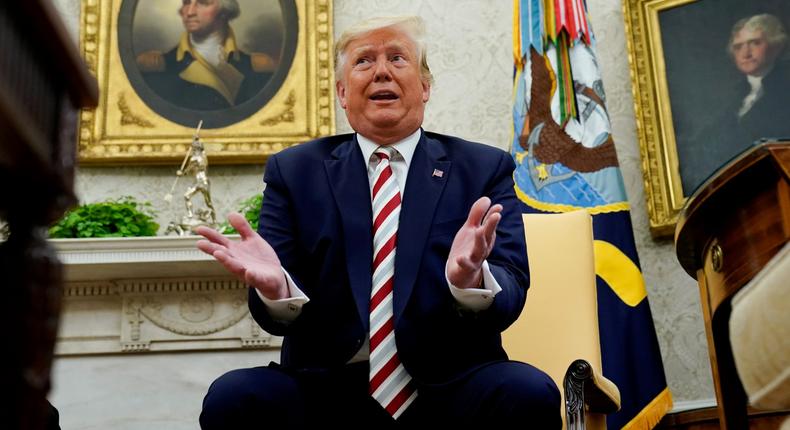 FILE PHOTO: U.S. President Donald Trump answers questions from reporters sitting in front of former U.S. presidents George Washington and Thomas Jefferson as he meets with Romania's President Klaus Iohannis in the Oval Office of the White House in Washington, U.S. August 20, 2019.   REUTERS/Kevin Lamarque/File Photo