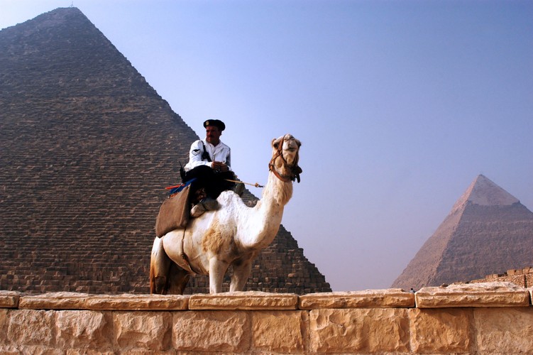 Egipski policjant pilnuje zagranicznych turystów. Piramid nie musi