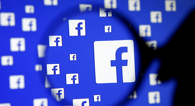 FILE PHOTO: A man poses with a magnifier in front of a Facebook logo on display in this illustration taken in Sarajevo, Bosnia and Herzegovina, December 16, 2015. REUTERS/Dado Ruvic/Illustration/File Photo