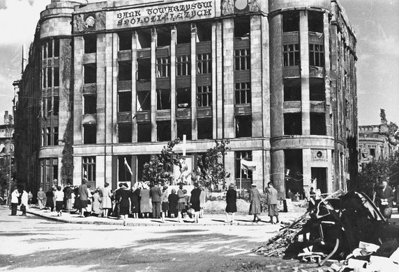 Rok 1945, pierwsza rocznica powstania warszawskiego – ludność zgromadzona wokół ołtarza ulicznego ustawionego przed uszkodzonym gmachem Banku Towarzystw Spółdzielczych.
