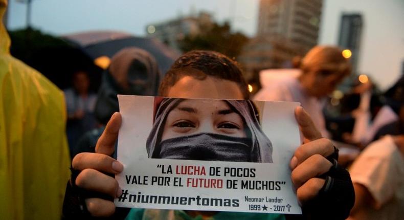 An opposition activist holds a sign reading The fight of the few is for the future of the many during a protest against Venezuelan President Nicolas Maduro in Caracas on July 13, 2017