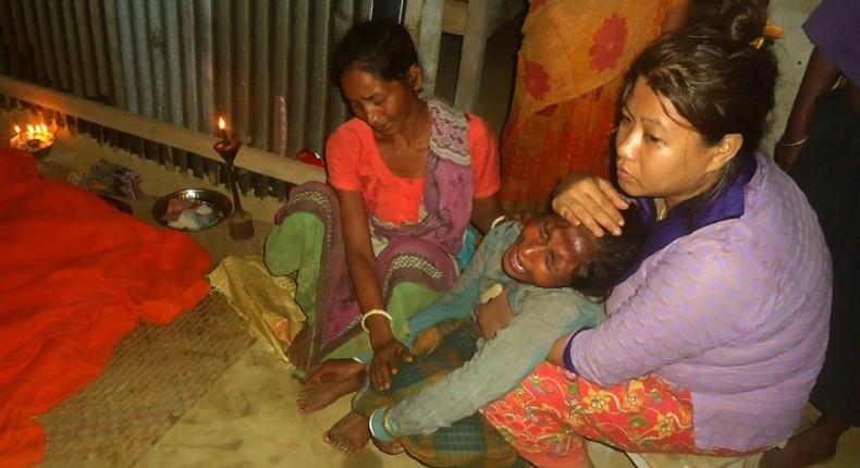 A Bangladeshi woman mourns next to bodies of relatives (not pictured) after a landslide in Bandarban