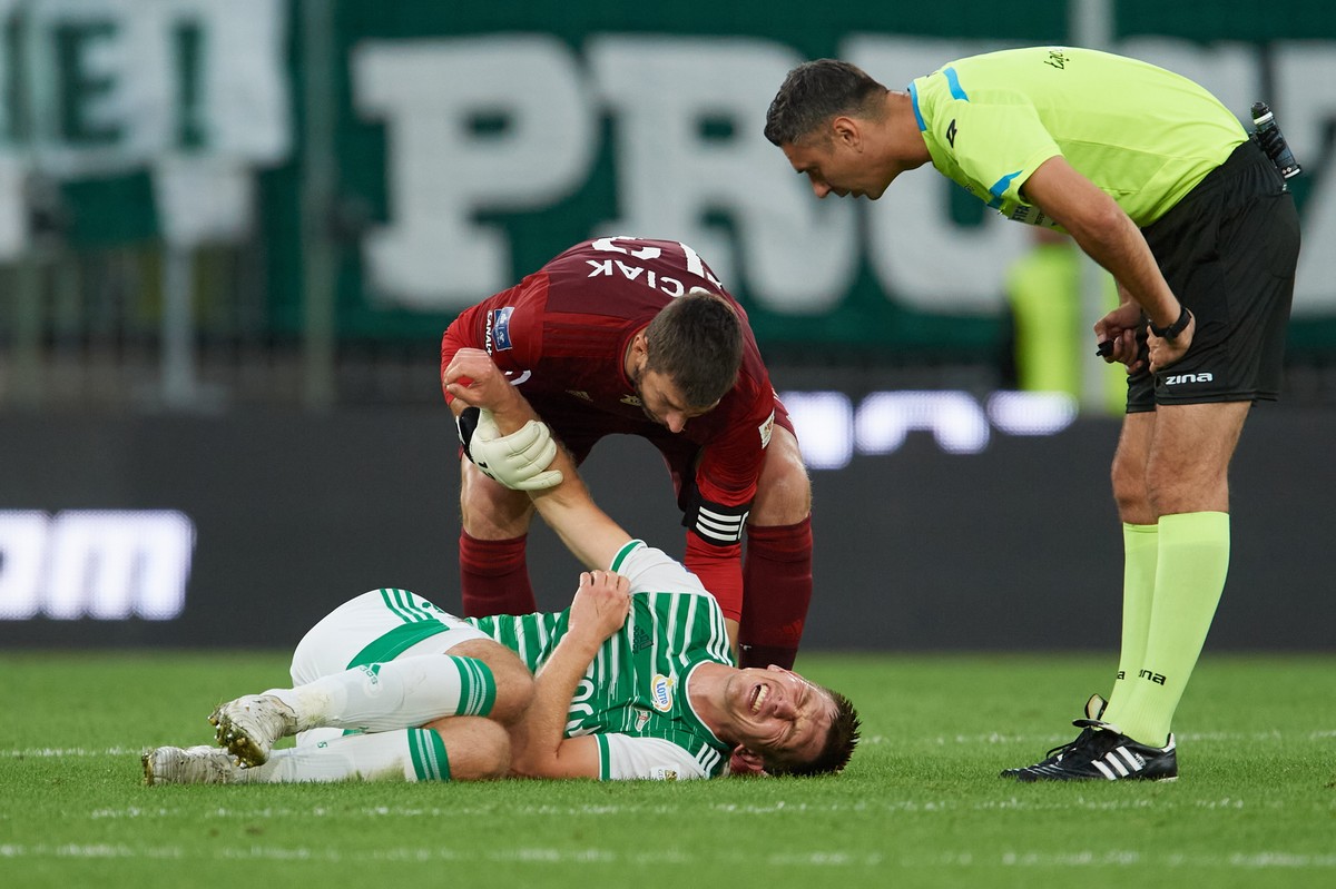 Zawodnik Lechii Gdańsk Michał Nalepa (leży) i bramkarz Dusan Kuciak (L) oraz sędzia Krzysztof Jakubik (P) podczas meczu Ekstraklasy piłkarzy z Wartą Poznań