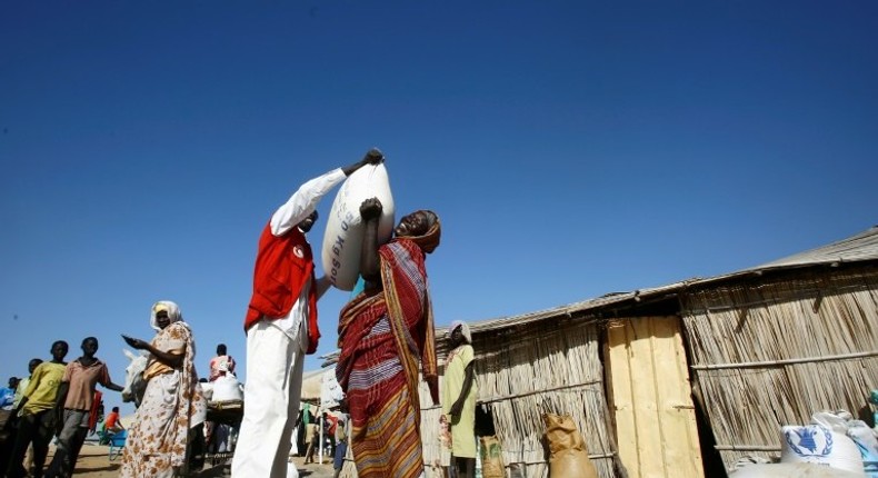 South Sudanese refugees collect aid food at a Refugee Waiting Centre in Al-Eligat area along the border in Sudan's White Nile state on February 27, 2017