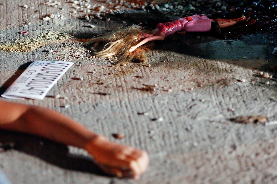 A 17-year-old girl lays dead next to her doll after she and her friend were killed by unknown gunmen, in Manila, Philippines, early on October 26, 2016. A cardboard sign reading, "You are a (drug) pusher, you are an animal" was found with the body of girl's friend, police said.