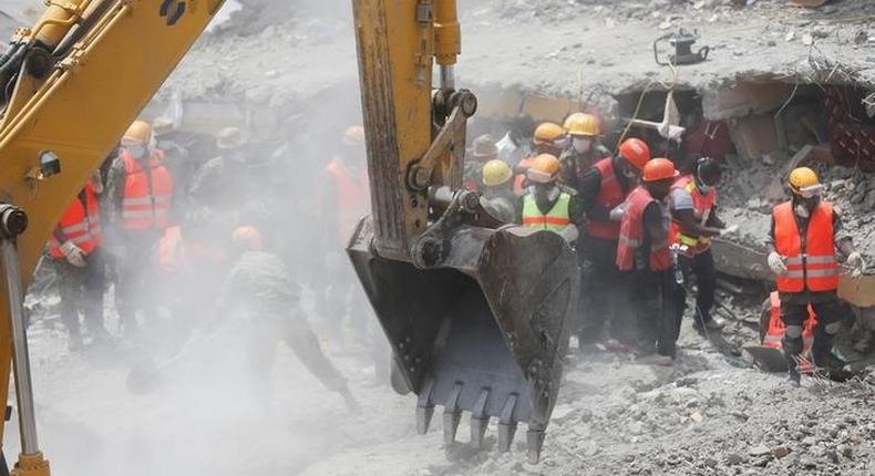 Rescuers use an excavator as they attempt to evacuate a woman from the rubble of a six-storey building that collapsed last Friday after days of heavy rain, in Nairobi, Kenya May 5, 2016. 