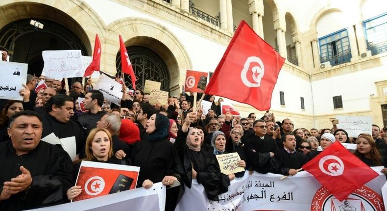 Tunisian lawyers shout anti-government slogans during a demonstration against a draft 2017 budget that would impose a public sector pay freeze on December 6, 2016 outside Tunis law court