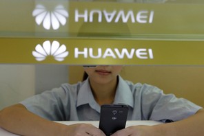 FILE PHOTO: A sales assistant looks at her mobile phone as she waits for customers behind a counter 