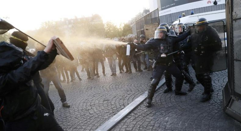 Anti-fascist demonstrators clash with police in Paris after the first round of voting in the country's presidential elections. Centrist Emmanuel Macron and far-right leader Marine Le Pen will contest the May 7 runoff, according to early projections