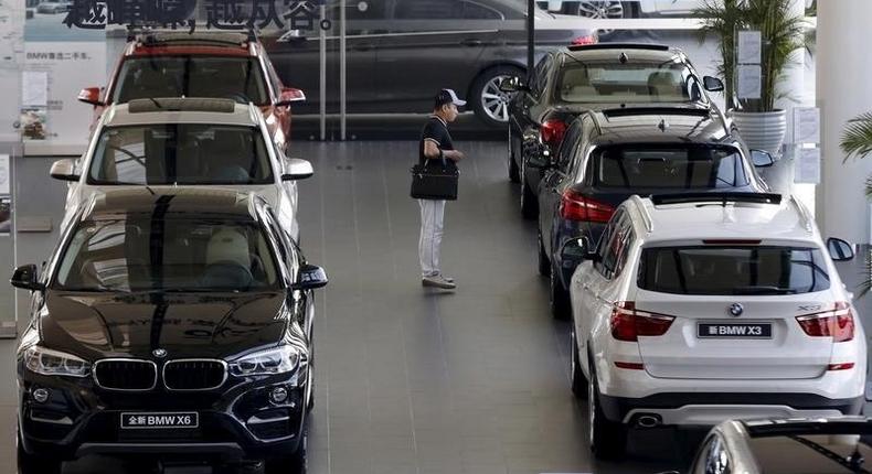 A man takes a look at BMW cars at a dealer shop in Beijing, China, September 11, 2015.    REUTERS/Kim Kyung-Hoon