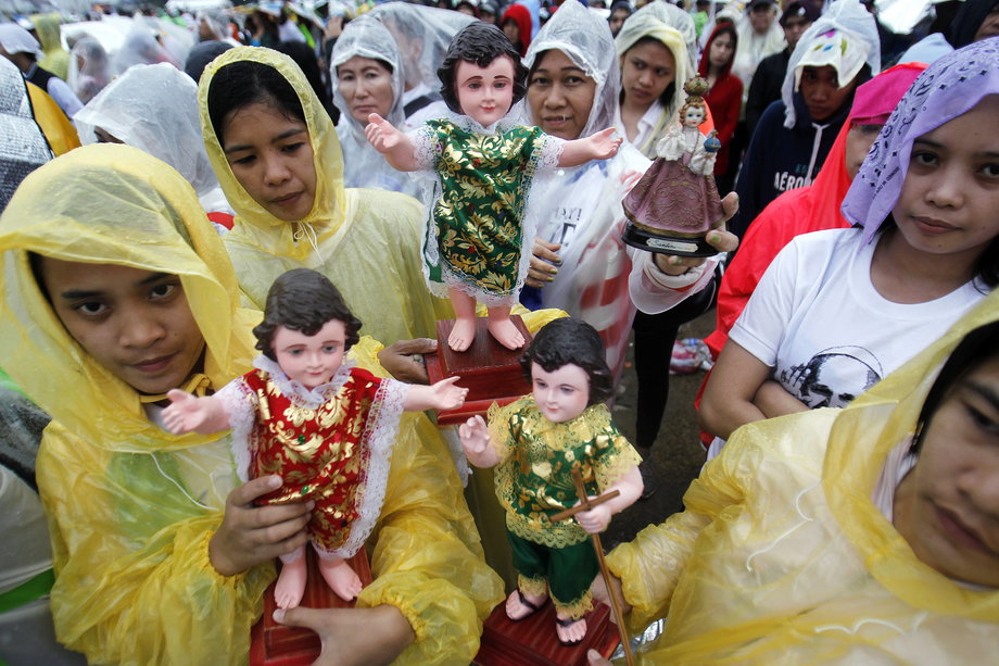 Catholic faithful hold religious statues during an open-air mass led by Pope Francis at Rizal Park in Manila, January 18, 2015.