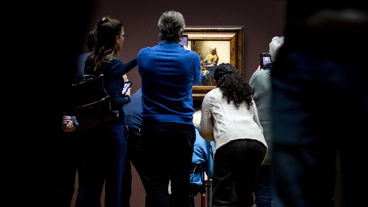 Zwiedzający oglądają obraz Mleczarka (Het Melkmeisje) Johannesa Vermeera podczas otwarcia wystawy Vermeera w Rijksmuseum w Amsterdamie.