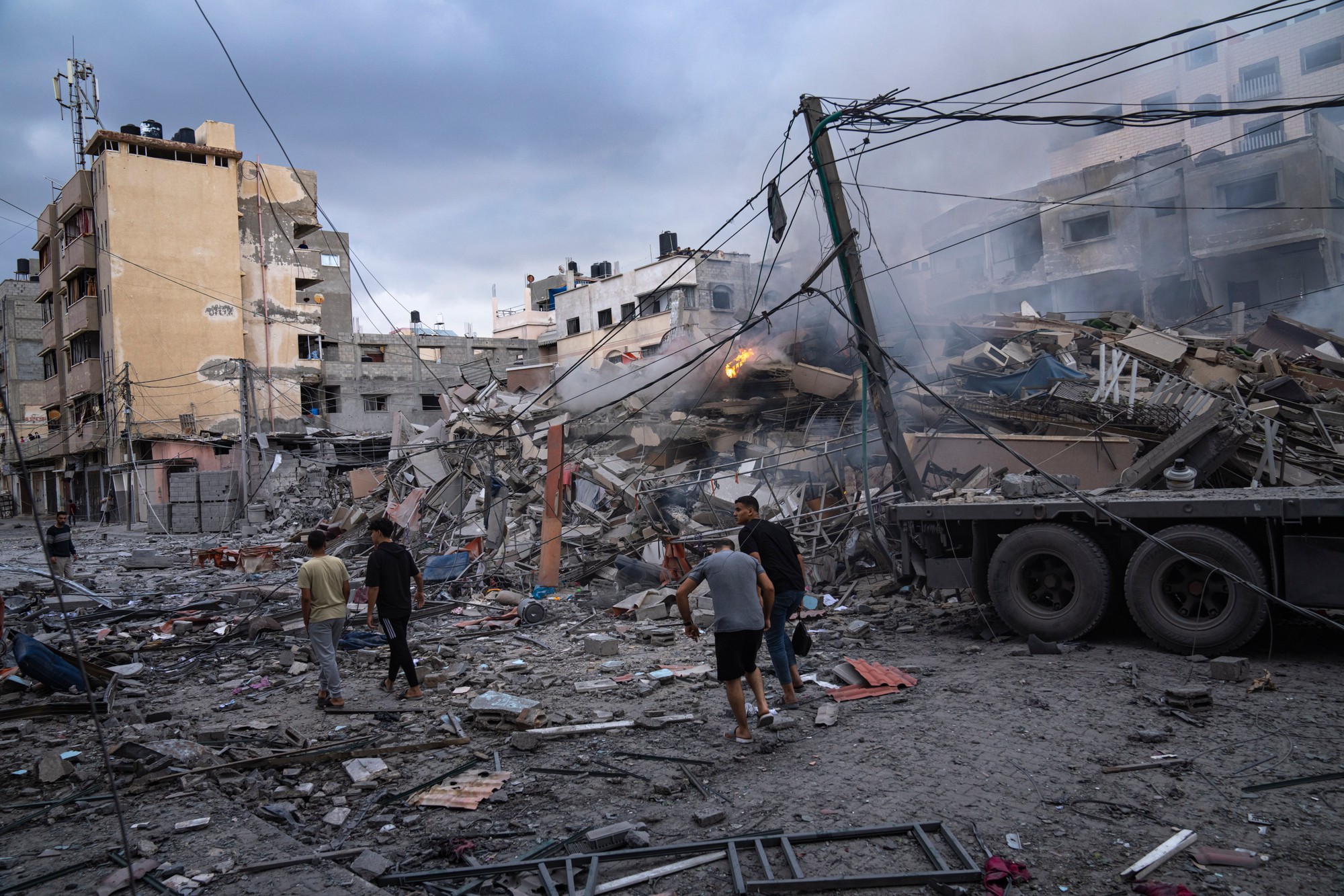 Na fotografii je zachytená situácia po útokoch Hamasu na Izrael KK18 Gaza - kde Palestínčania kráčajú medzi vyskytujúcimi sa ruinami po izraelských leteckých útokoch, ktoré zrovnali so zemou časť štvrte v meste Gaza dňa  10. októbra 2023.