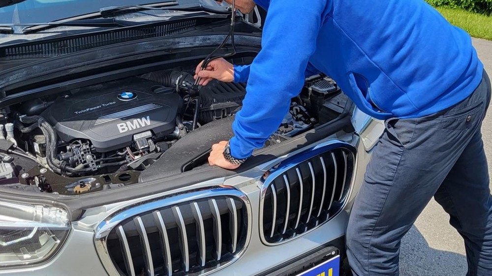 Technik Komplexného preverenia vozidiel kontrolujte jazdené auto značky BMW.