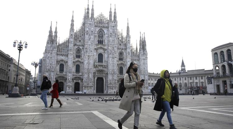 A koronavírus elleni védekezésül szájmaszkot viselnek turista a milánói dóm előtt 2020. február 23-án.