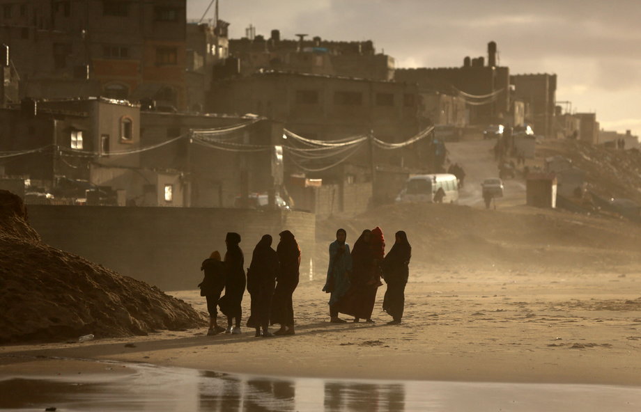 Wysiedleni Palestyńczycy idą plażą w Deir el-Balah.
