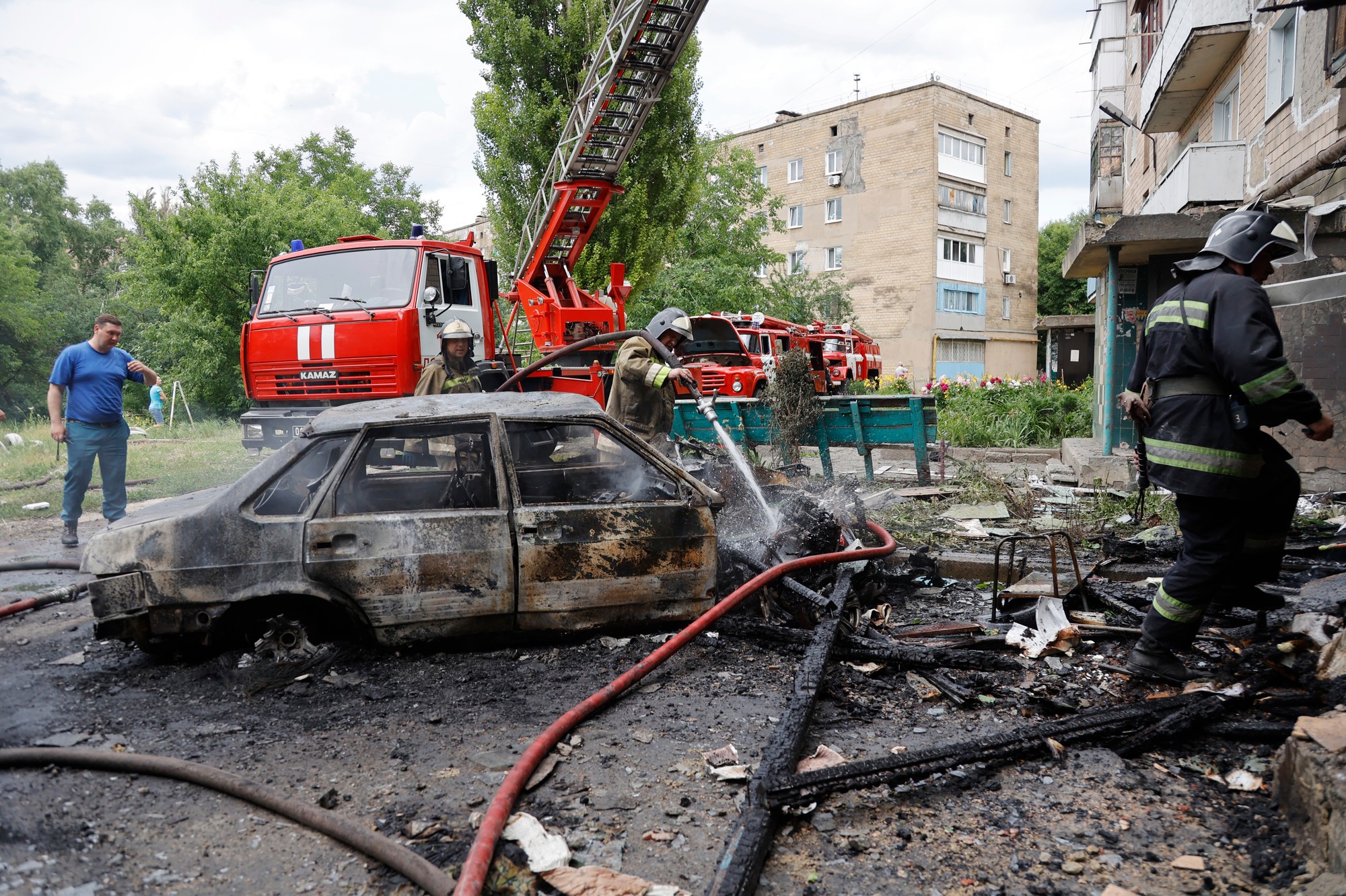 Hasiči hasia obytnú budovu a autá po ostreľovaní v Donecku.