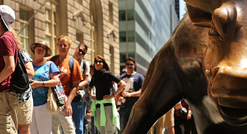 People line up near Wall Street's Bull statue.