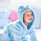 Baby in bathrobe or towel after bath on white bed