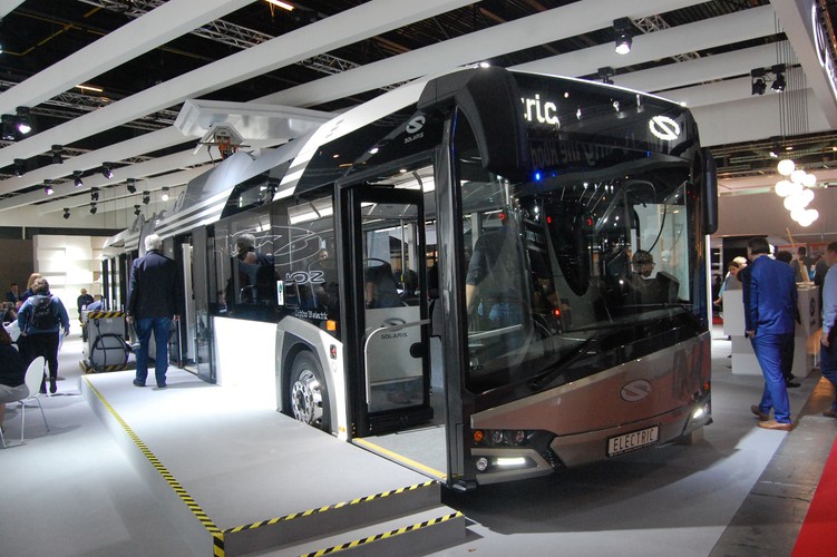 Elektryczny, przegubowy solaris

Na Belgijskich targach dość duże stoisko miał polski Solaris, który chwalił się głównie 
najnowszym przegubowym autobusem elektrycznym. Do tej pory firma produkowała głównie krótsze „elektryki”. Teraz spodziewając się zamówień od miast stawia także na te osiemnastometrowe. Zaprezentowany przegubowiec może być ładować baterie w dwojaki sposób – przy pomocy wtyczki (zazwyczaj w zajezdni)  lub zamontowanego na dachu pantografu. W tym drugim przypadku autobus może nieco przypominać trolejbus. Do sieci jest jednak podłączany tylko w czasie postoju na pętli, gdzie muszą powstać odpowiednie ładowarki. W przypadku ładowania baterii z pantografu pojazd może dziennie pokonać tyle samo kilometrów, co autobus tradycyjny. Wkrótce 18-metrowy elektryczny solaris testowany będzie w Warszawie.