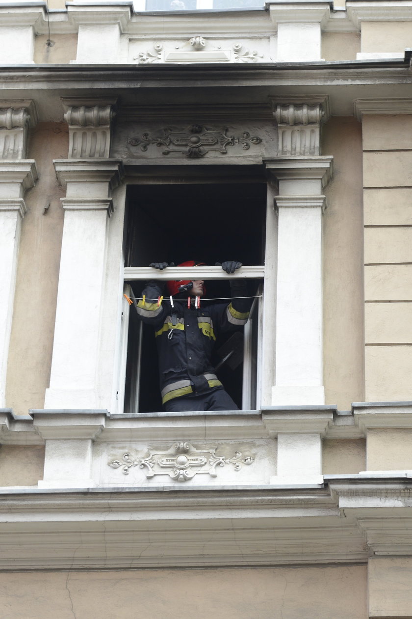 Strażak w oknie spalonego mieszkania