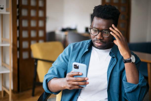 A man looking at his phone worried