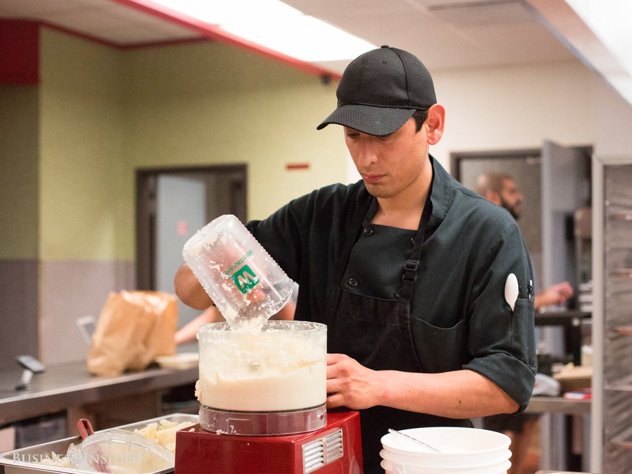 A cook at Mealmade pulses cauliflower in a food processor before the daily lunch rush.