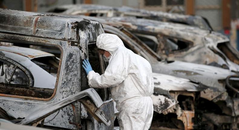 A French police officer inspects burned vehicles outside the Splendid Hotel in Ouagadougou, Burkina Faso, January 17, 2016. REUTERS/Joe Penney