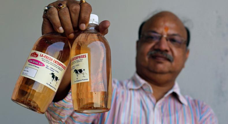 An Indian holding bottled Cow Urine