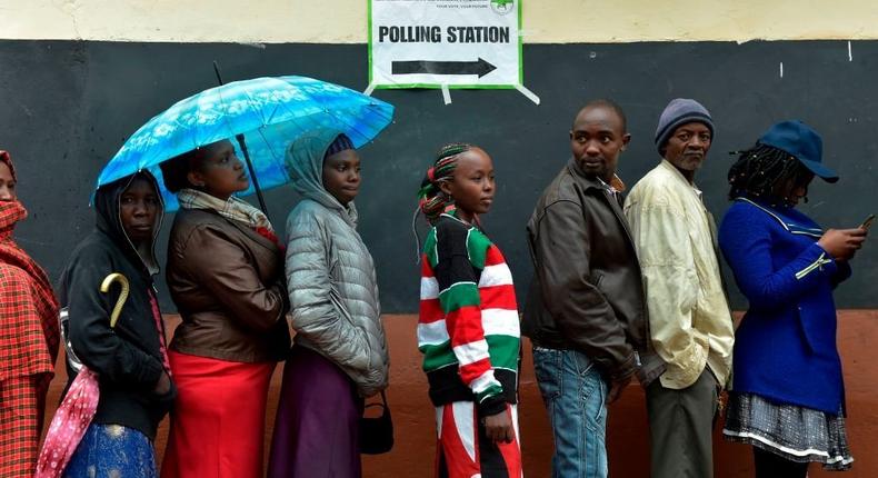 Voters queue at a polling station at Mutomo primary school in Kiambu on October 26, 2017, as polls opened for presidential elections. (Photo by SIMON MAINA/AFP via Getty Images)