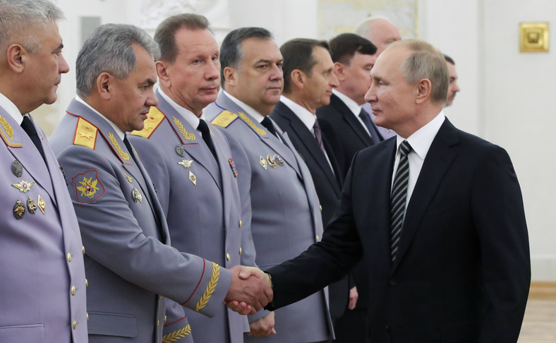 Władimir Putin ściska dłoń Siergieja Szojgu, po prawej Wiktor Zołotow, po lewej Władimir Kołokolcew.