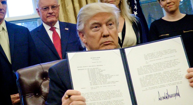 Donald Trump signs an executive order in the Oval Office