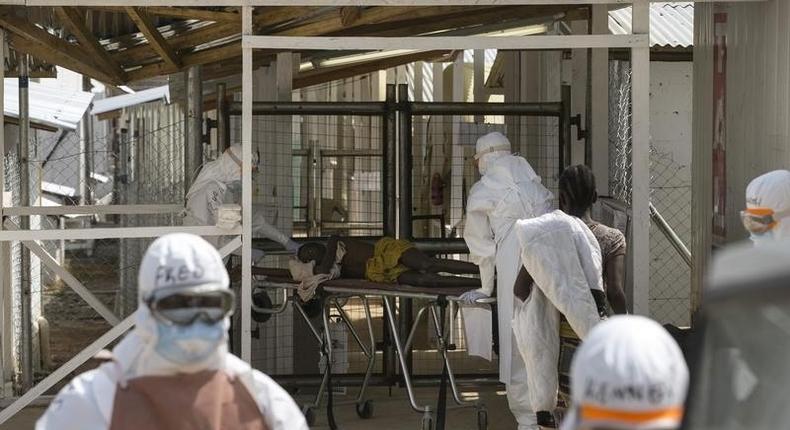 Health workers push a wheeled stretcher holding a newly admitted Ebola patient, 16-year-old Amadou, in to the Save the Children Kerry town Ebola treatment centre outside Freetown, Sierra Leone, December 22, 2014.  
REUTERS/Baz Ratner