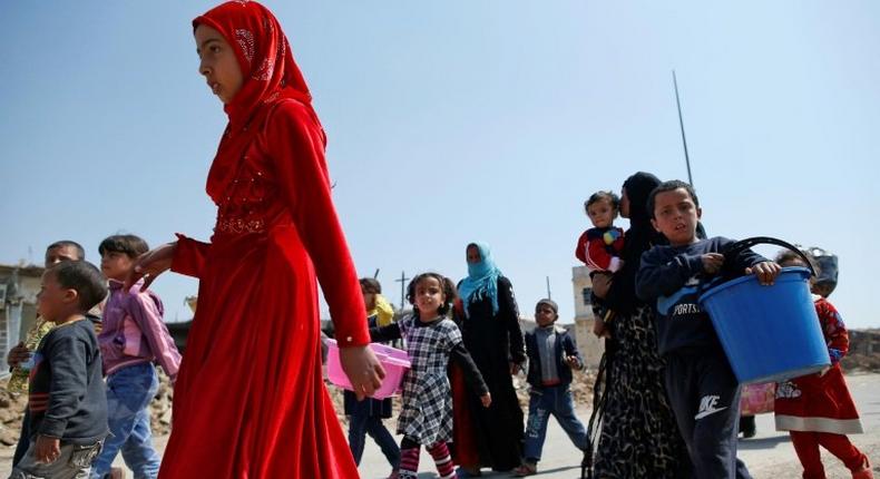 Iraqis fleeing their homes in Mosul's Old City carry their belongings on March 30, 2017