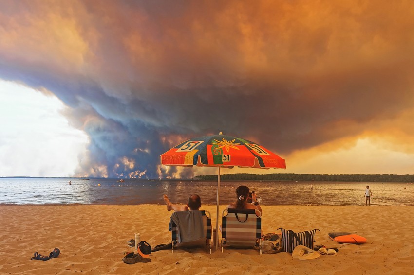 Posetioci plaže odmaraju se na plaži Mučik na obali jezera Lakano u Lakanou, na jugozapadu Francuske, dok požar besni u Žirondi, 24. jul 2026.