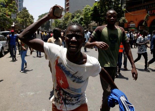 A supporter of the opposition National Super Alliance coalition holds up a stone during a protest ca