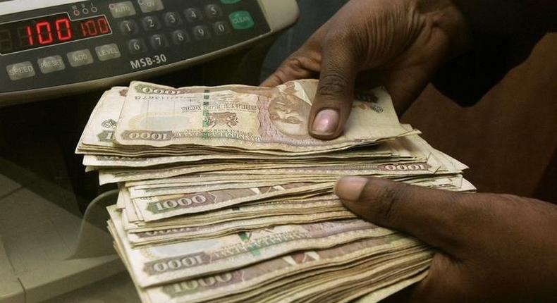 A currency dealer counts Kenya shillings at a money exchange counter in Nairobi October,  file.  REUTERS/Antony Njuguna