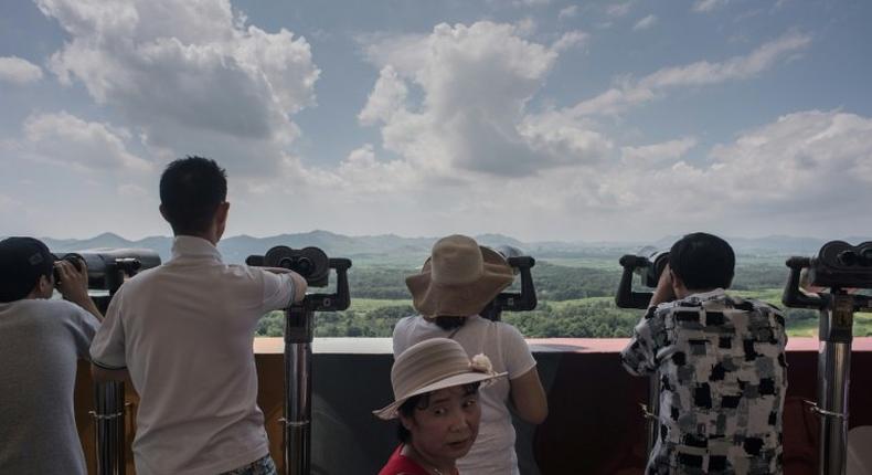 Tourists look out towards North Korea at an observation point within the Demilitarized Zone separating North and South Korea