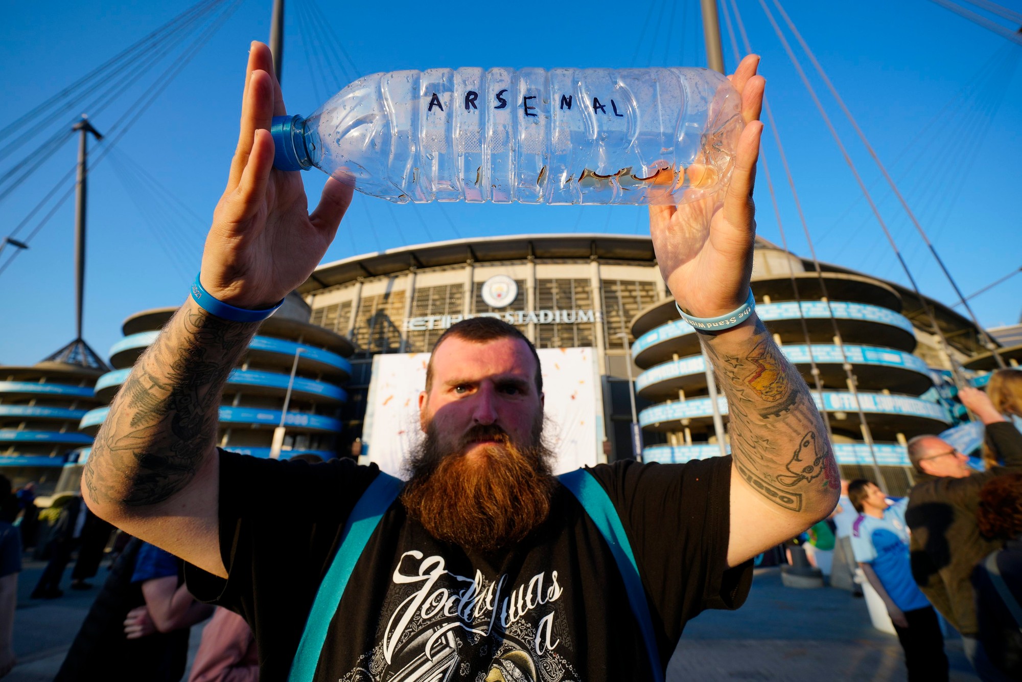 Fanúšikovia Manchestru City oslavujú obhajovu titulu pred Etihad Stadium.