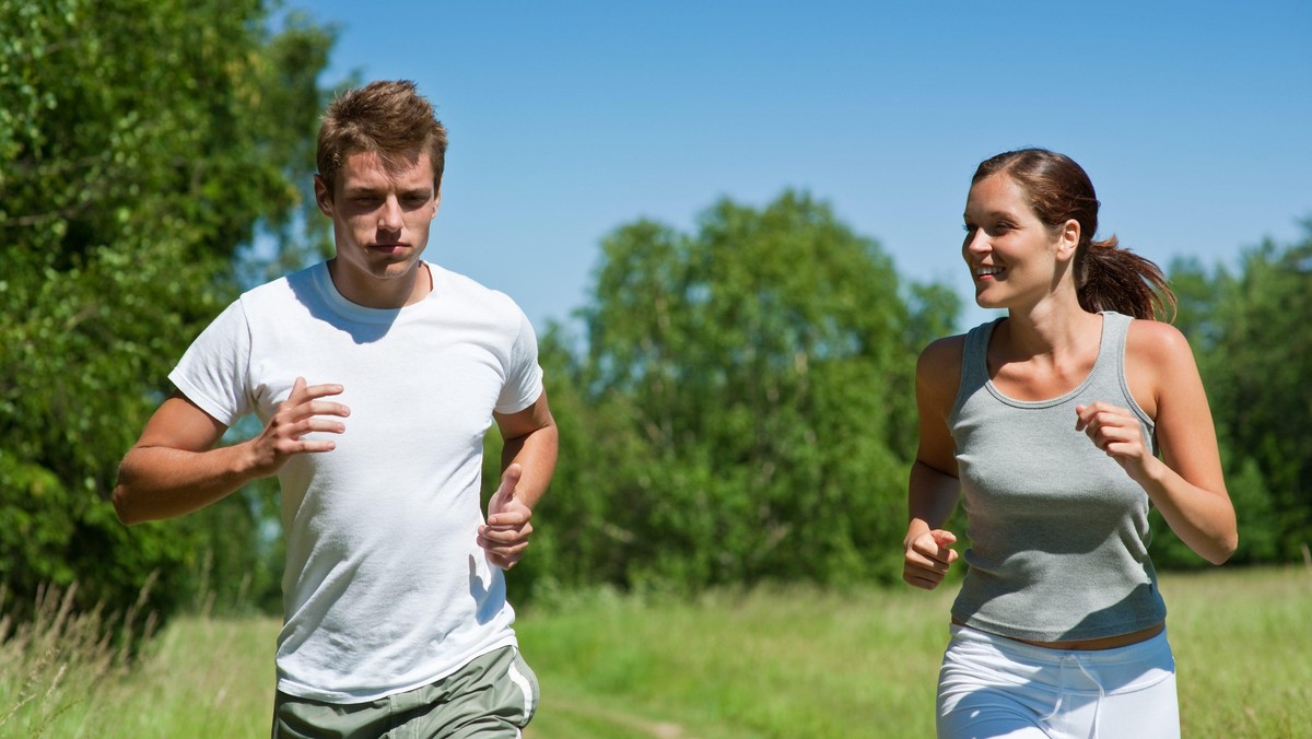 Sportive man and woman jogging outdoors