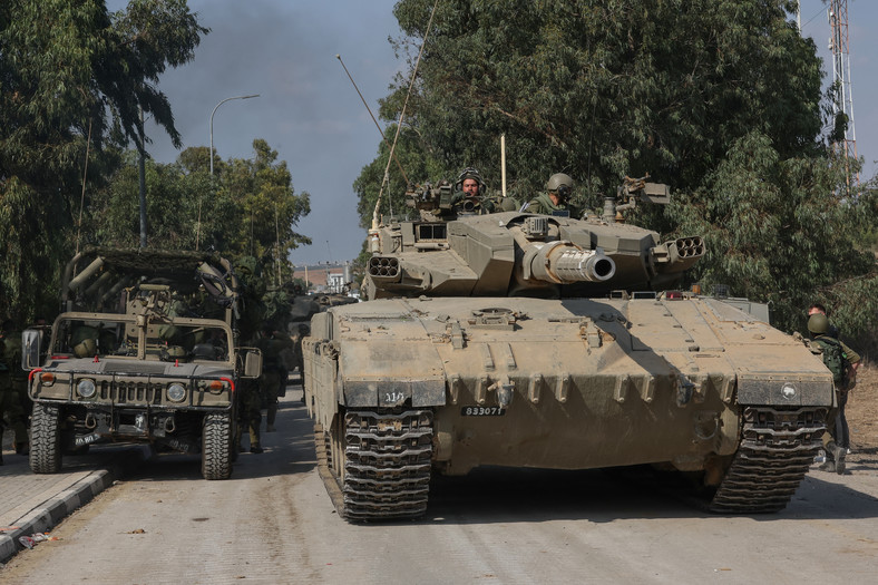 Izraelskie czołgi opuszczają kibuc Kfar Aza w południowym Izraelu po inspekcji obszaru na granicy ze Strefą Gazy, 10 października 2023 r.