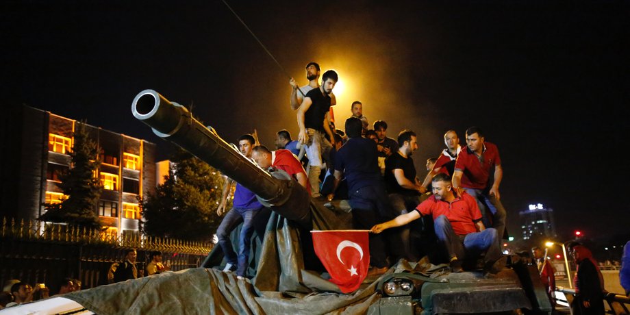 People stand on a Turkish army tank in Ankara, Turkey July 16, 2016.