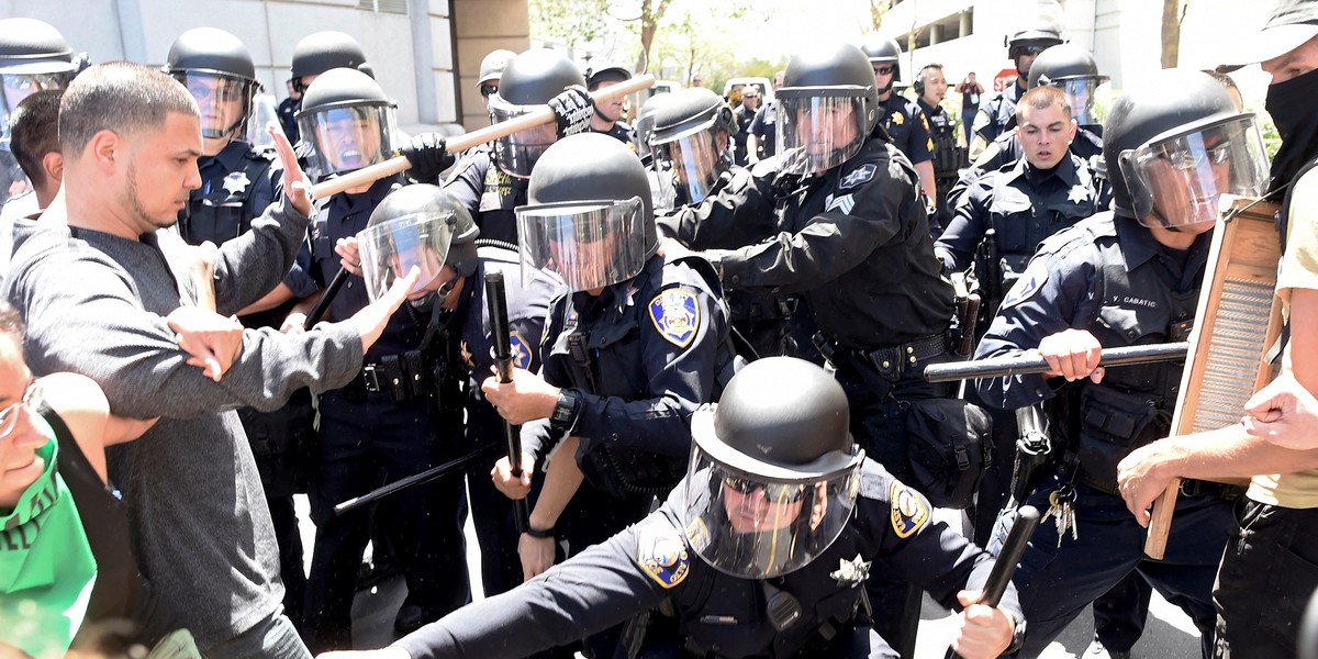 Police use batons to push back protesters outside the California Republican Party convention in Burlingame, California, on April 29.