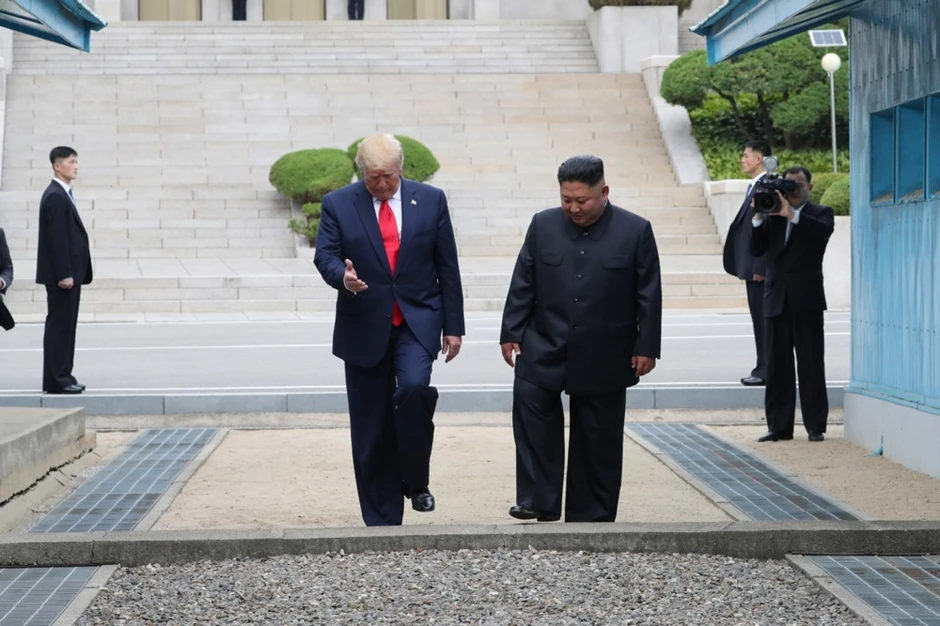 Donald Tramp i Kim Džong Un prelaze demarkacionu liniju u DMZ 30. juna 2019.