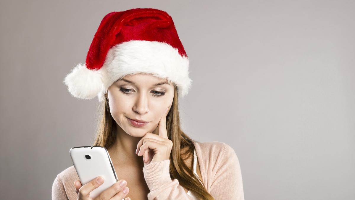 smartfon, kobieta w czapce świętego Mikołaja