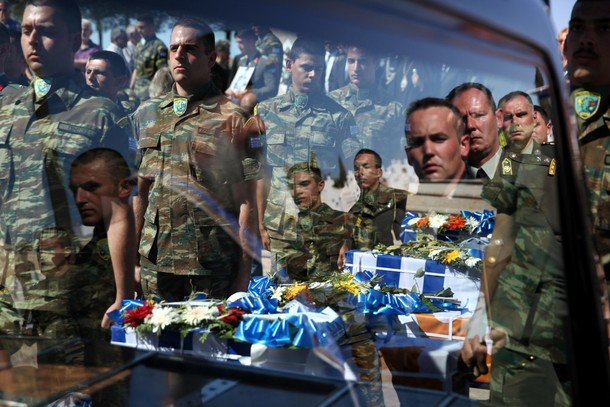 Greek soldiers hold caskets of soldiers draped in the Greek and Cypriot flags, at the Tymvos Macedon