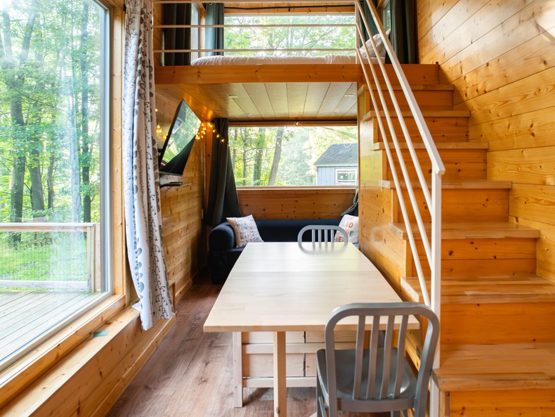 The dining table was next to the largest window in the house. It had drawers and could be extended to triple its size, with two foldout leaves.Since I stayed in the tiny home alone, I had no reason to use the full-sized table, but I unfolded both leaves anyway to see how the house would feel if I'd needed more space.At full length, the table was about the width of the staircase. It didn't infringe on the kitchen or the living room behind it.While moving the table, I noticed two wide drawers on the side of the staircase.